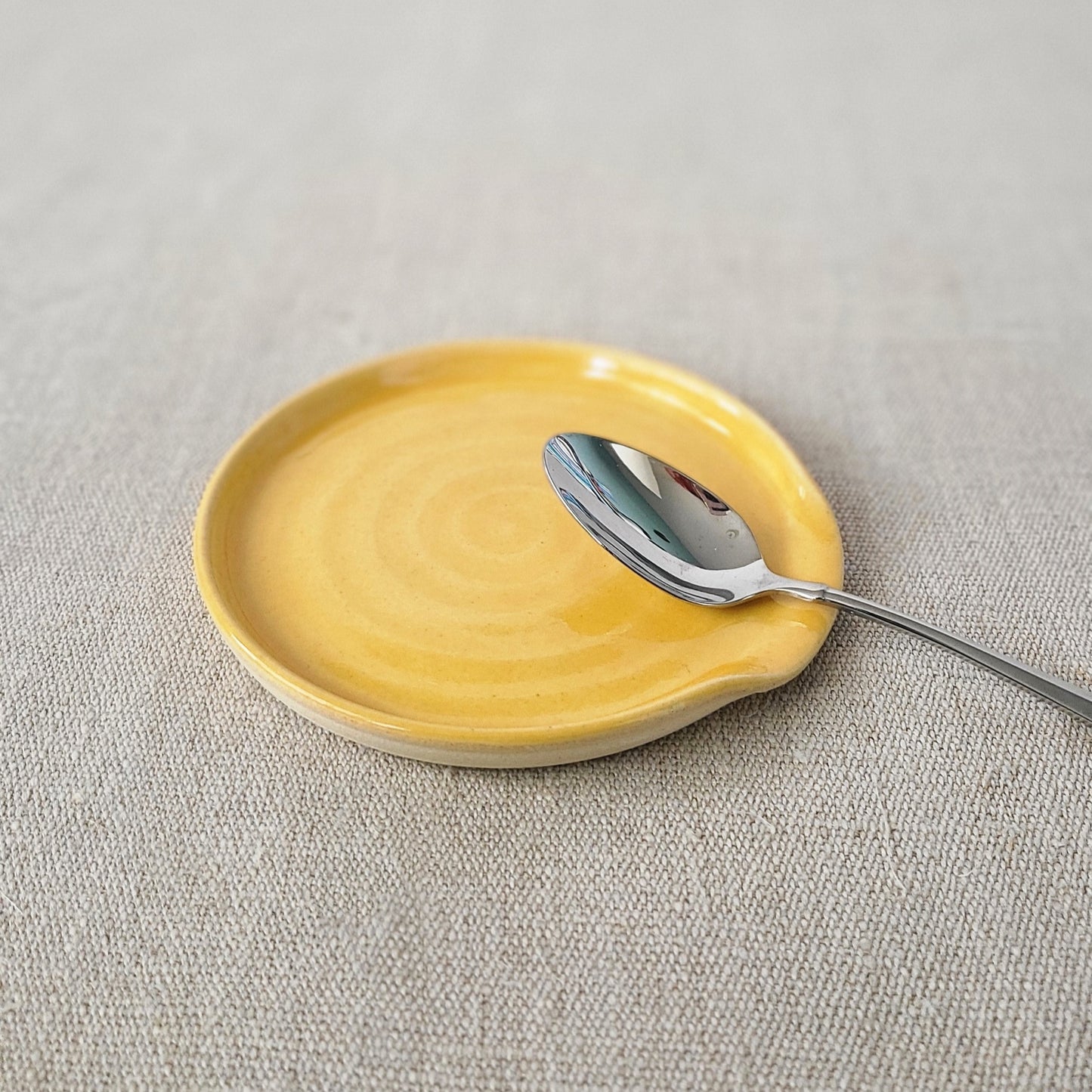 Yellow spoonrest with a silver teaspoon